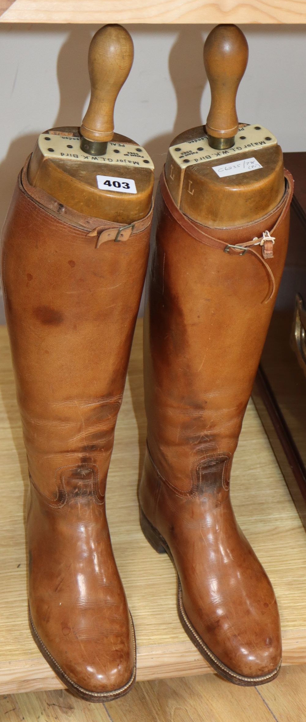 A pair of early 20th century tan leather boots and boot trees, trees marked Major G.L.W.K. Bird